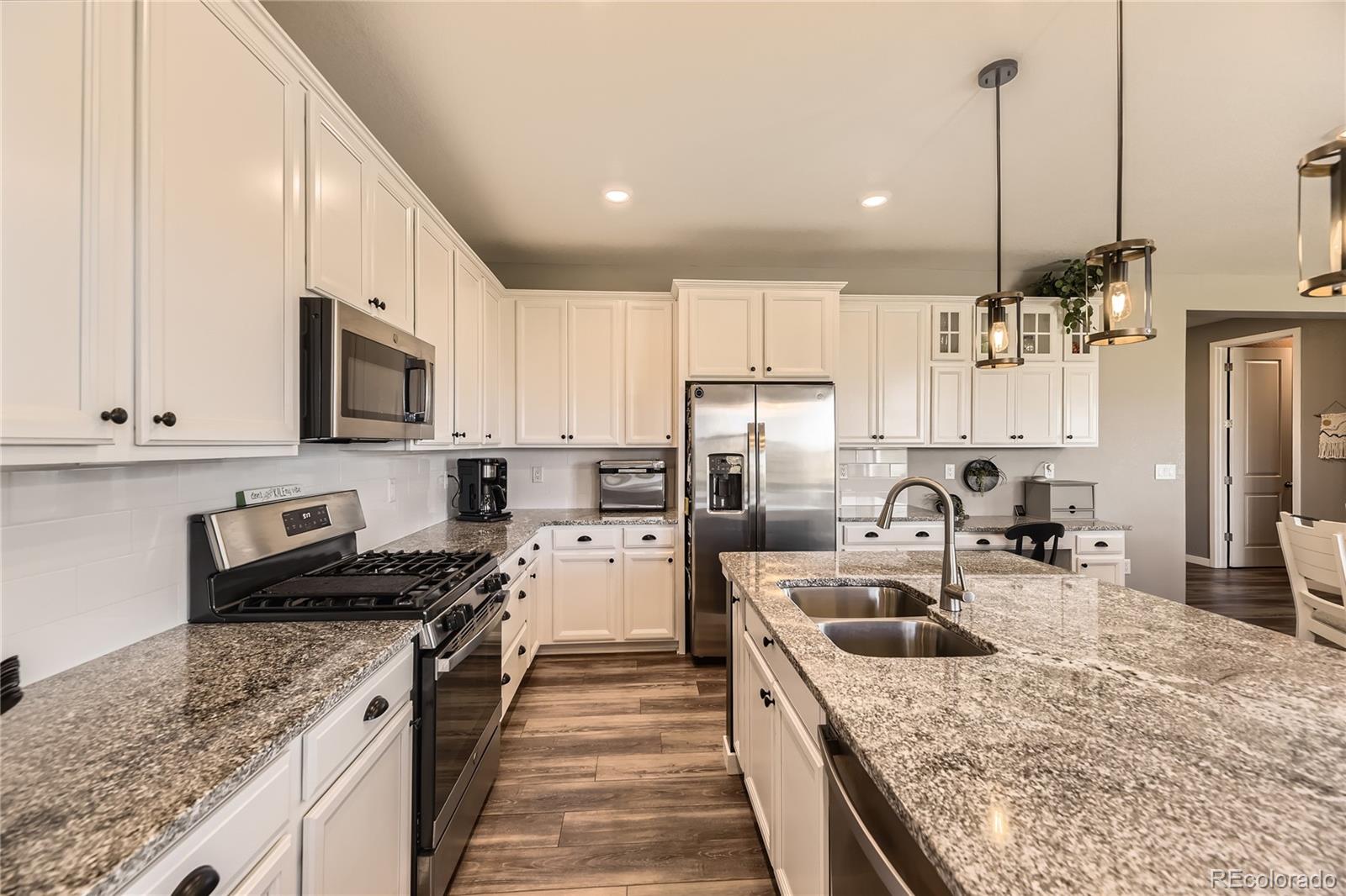 1182 Williams Loop Elizabeth, CO 80107 - Photo 13 of 42 a kitchen with stainless steel appliances granite countertop a sink stove and refrigerator