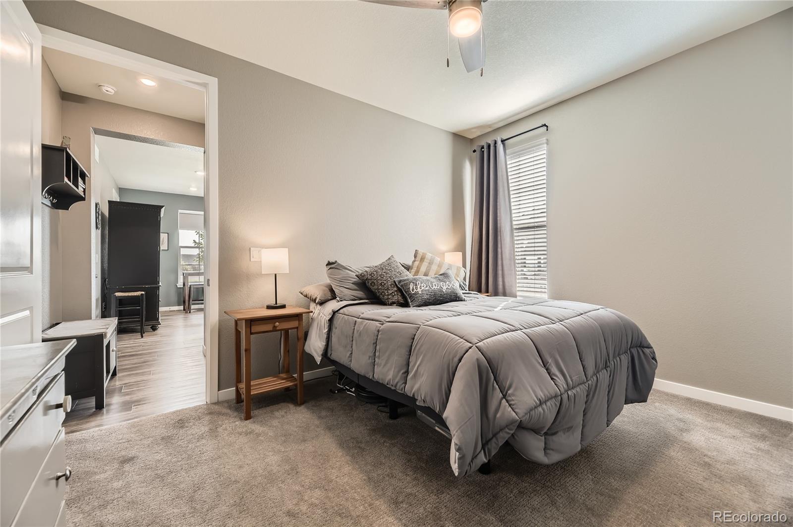 1182 Williams Loop Elizabeth, CO 80107 - Photo 29 of 42 a spacious bedroom with a bed and a chandelier