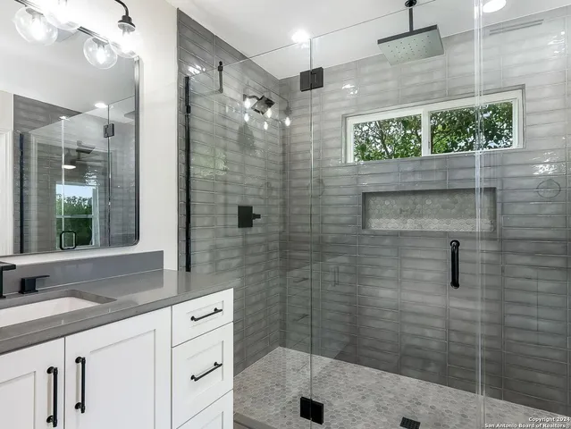 a bathroom with a shower sink and mirror