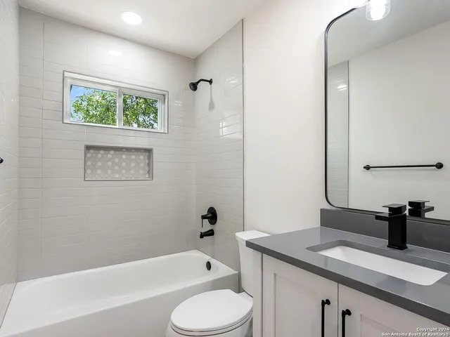 a bathroom with a granite countertop sink toilet and bathtub