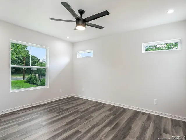 an empty room with a window and a ceiling fan