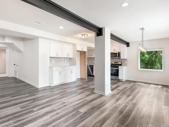 a view of a kitchen with wooden floor and a refrigerator