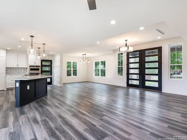 a large hall with lots of counter space wooden floor and windows