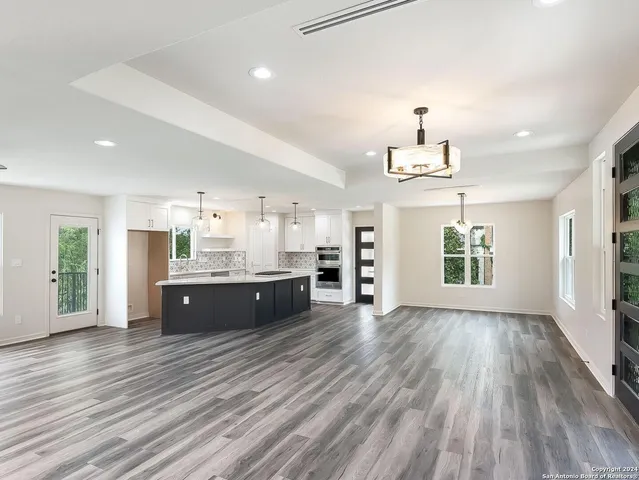 a large room with a lot of counter space and wooden floor
