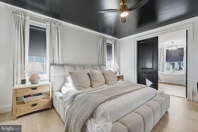 a bedroom with a large bed and a chandelier