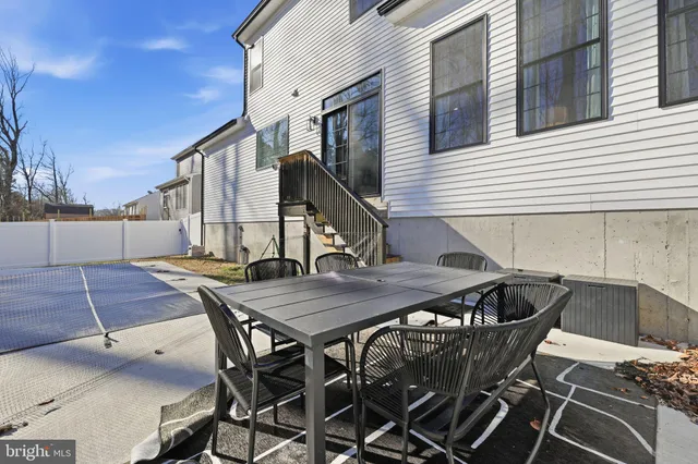 a backyard of a house with table and chairs