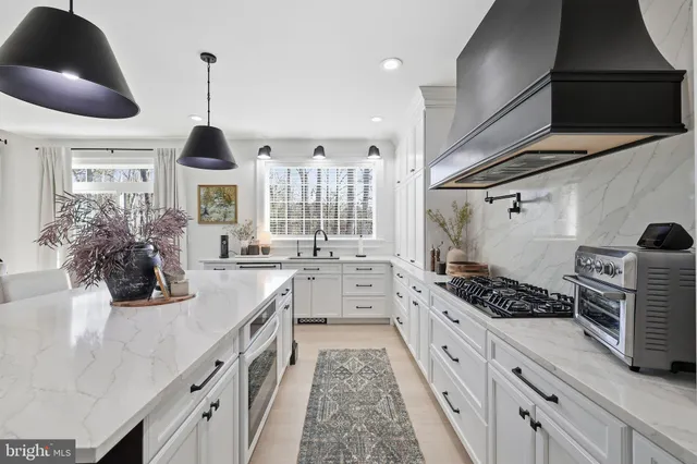 a kitchen with stainless steel appliances kitchen island a stove and a wooden floors