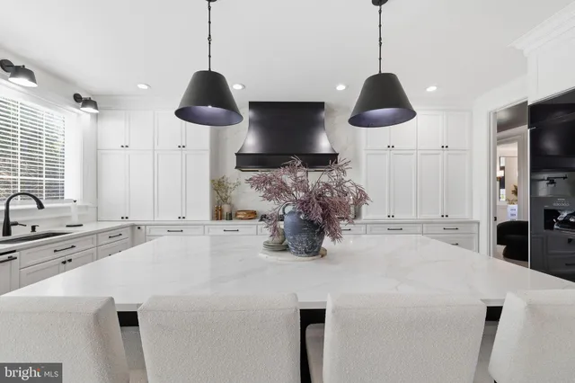 a kitchen with stainless steel appliances a stove a sink a microwave a dining table and chairs