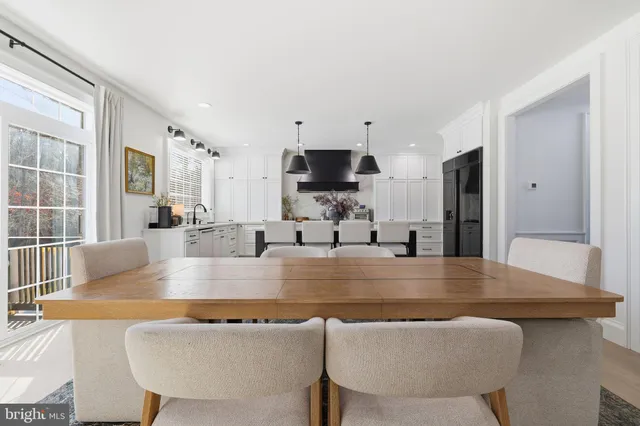 a view of kitchen island with stainless steel appliances furniture large window and wooden floor