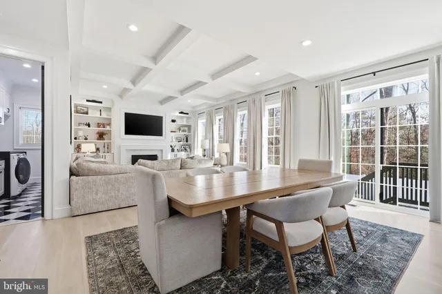 a dining room with furniture and large windows
