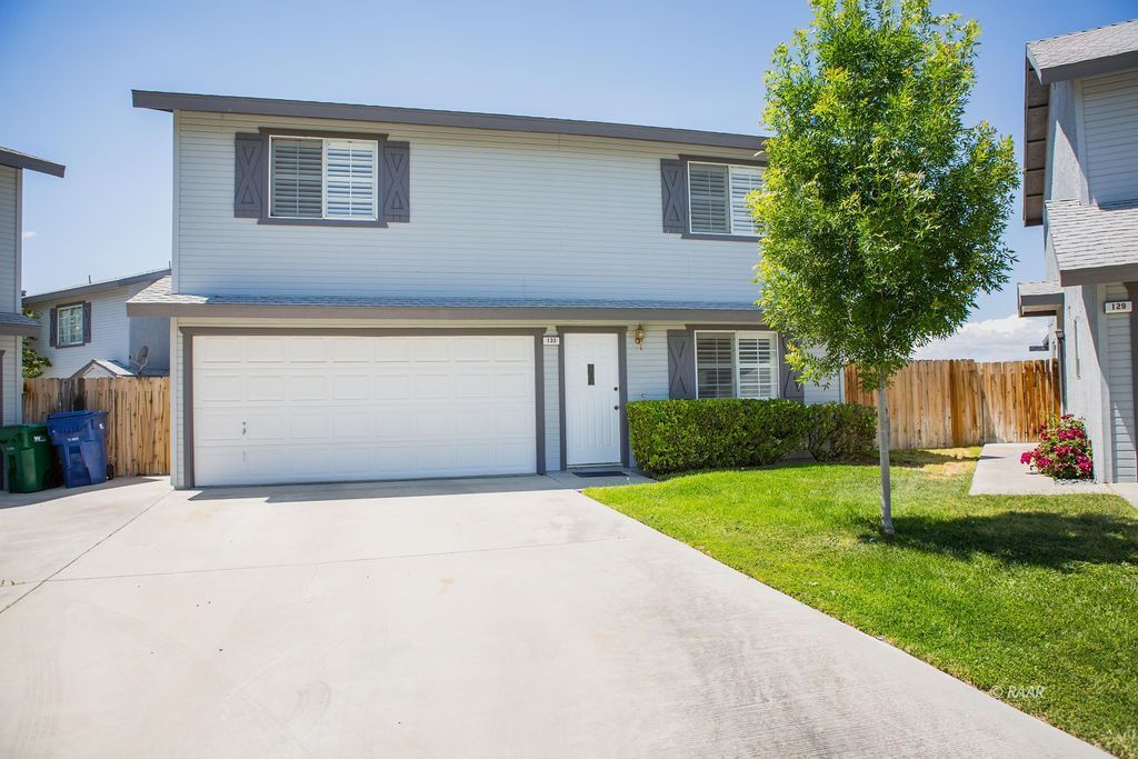 133 South Lilac Street Ridgecrest, CA 93555 - Photo 1 of 1 a front view of a house with a yard and garage