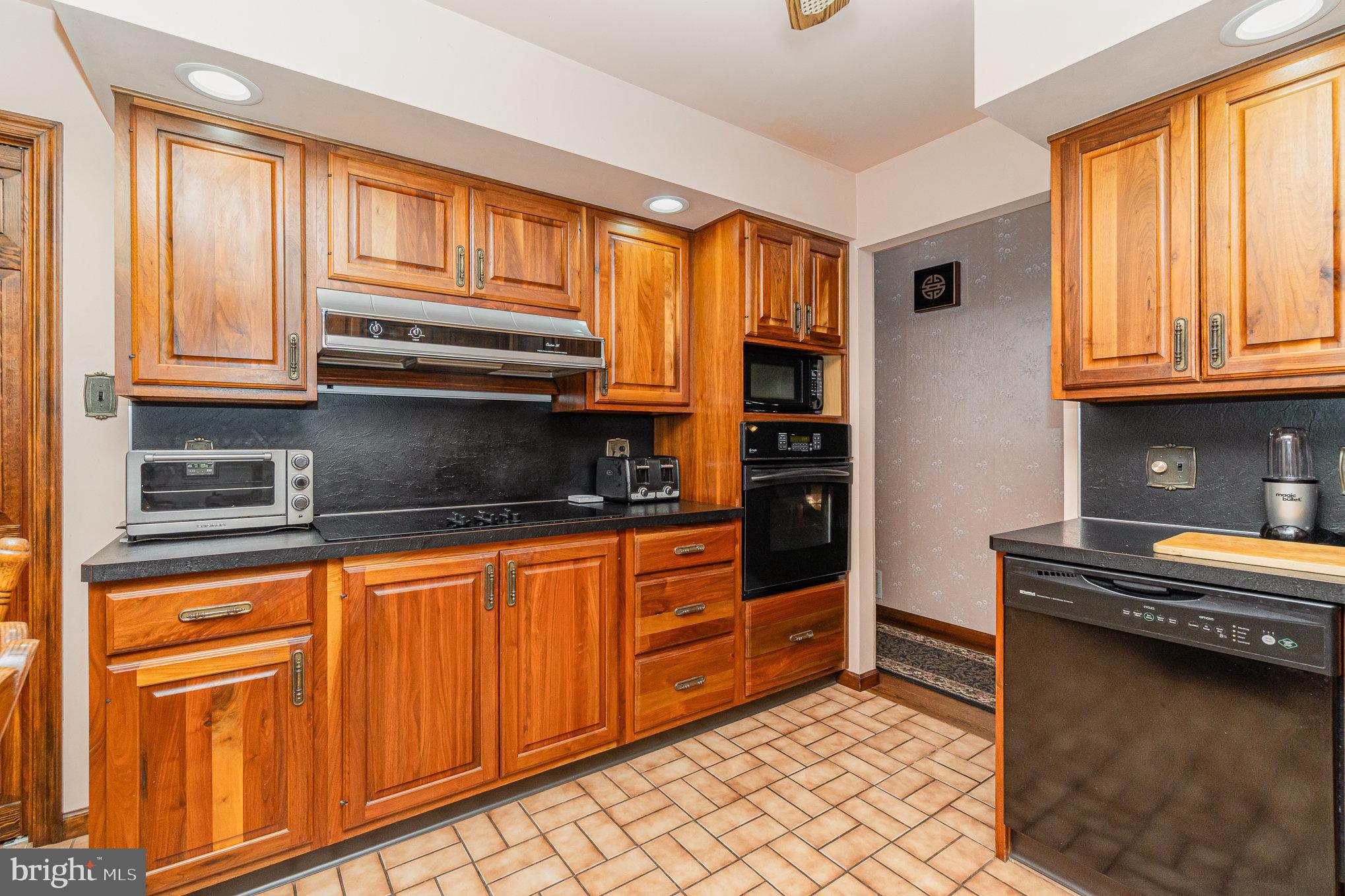48 Turnpike Road Ashland, PA 17921 - Photo 13 of 60 a kitchen with granite countertop wooden cabinets and a stove top oven