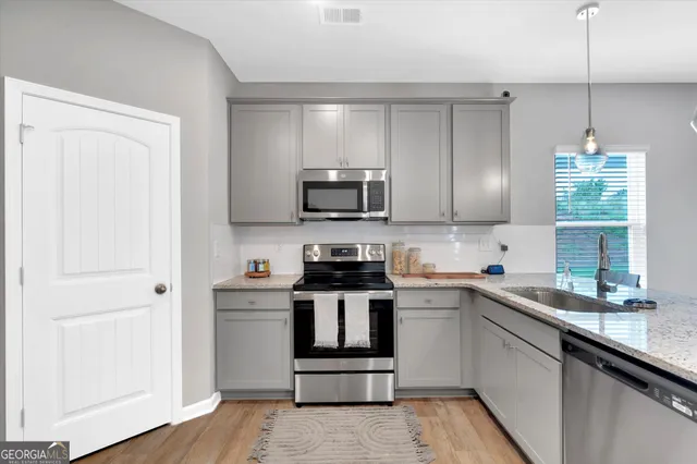 a kitchen with a sink a stove and cabinets