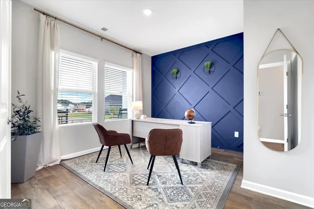 a workspace room with furniture and wooden floor