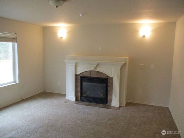 an empty room with a fireplace and window