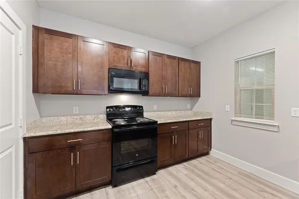a kitchen with stainless steel appliances granite countertop wooden cabinets and a stove top oven