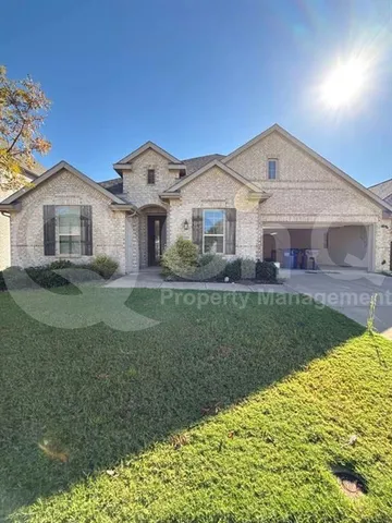 a front view of a house with a yard and potted plants