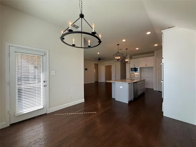 a view of kitchen with stainless steel appliances granite countertop cabinets and wooden floor