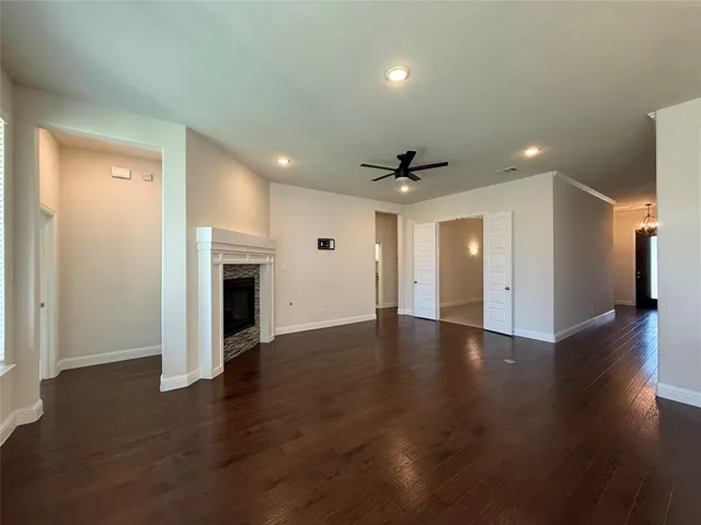 an empty room with wooden floor and fireplace