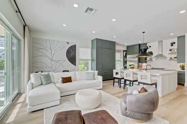 a kitchen with stainless steel appliances a sink a stove and a wooden floor