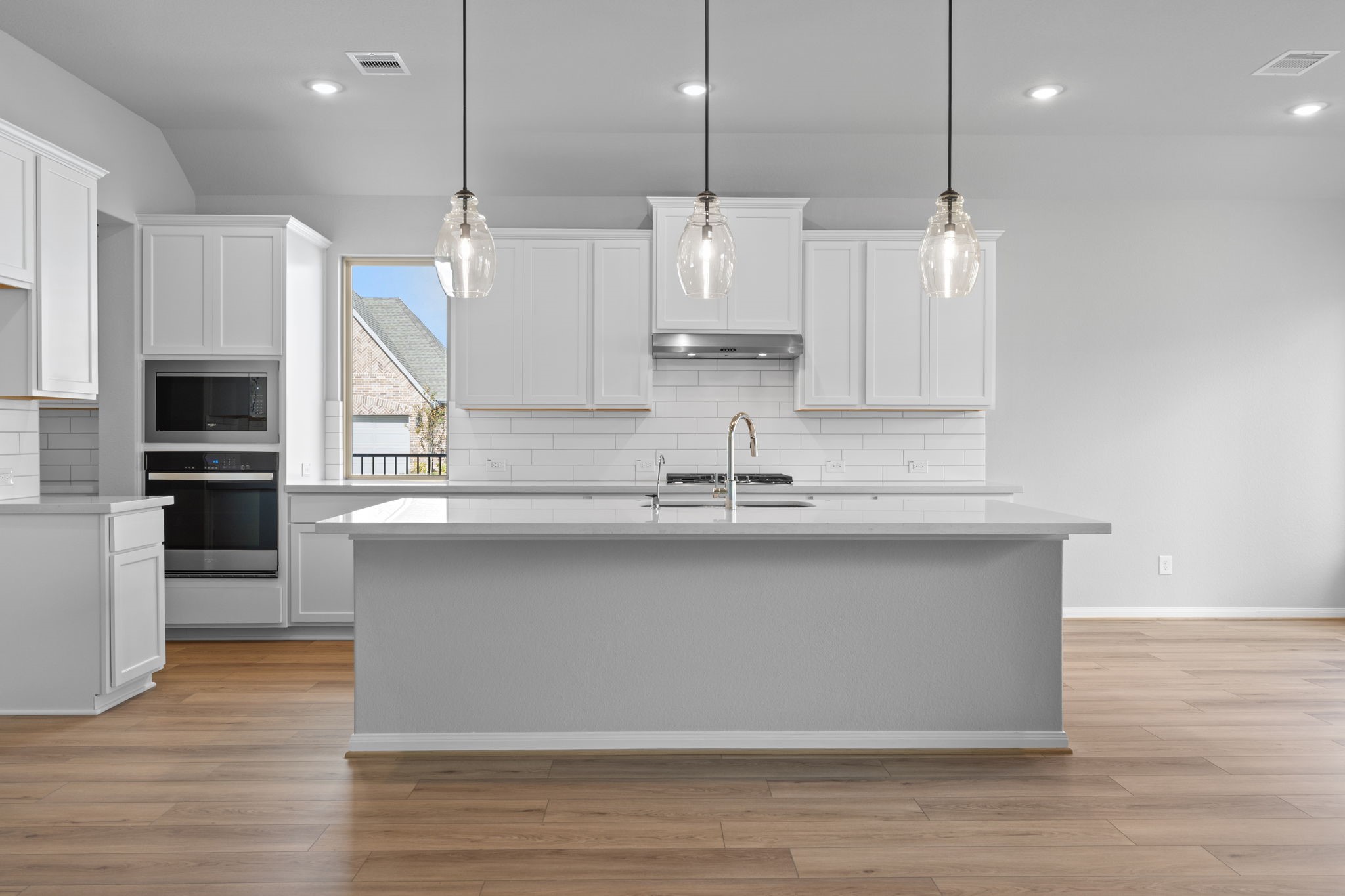 10726 Rattlebox Court Cypress, TX 77433 - Photo 3 of 36 a large kitchen with stainless steel appliances kitchen island a large island in the center