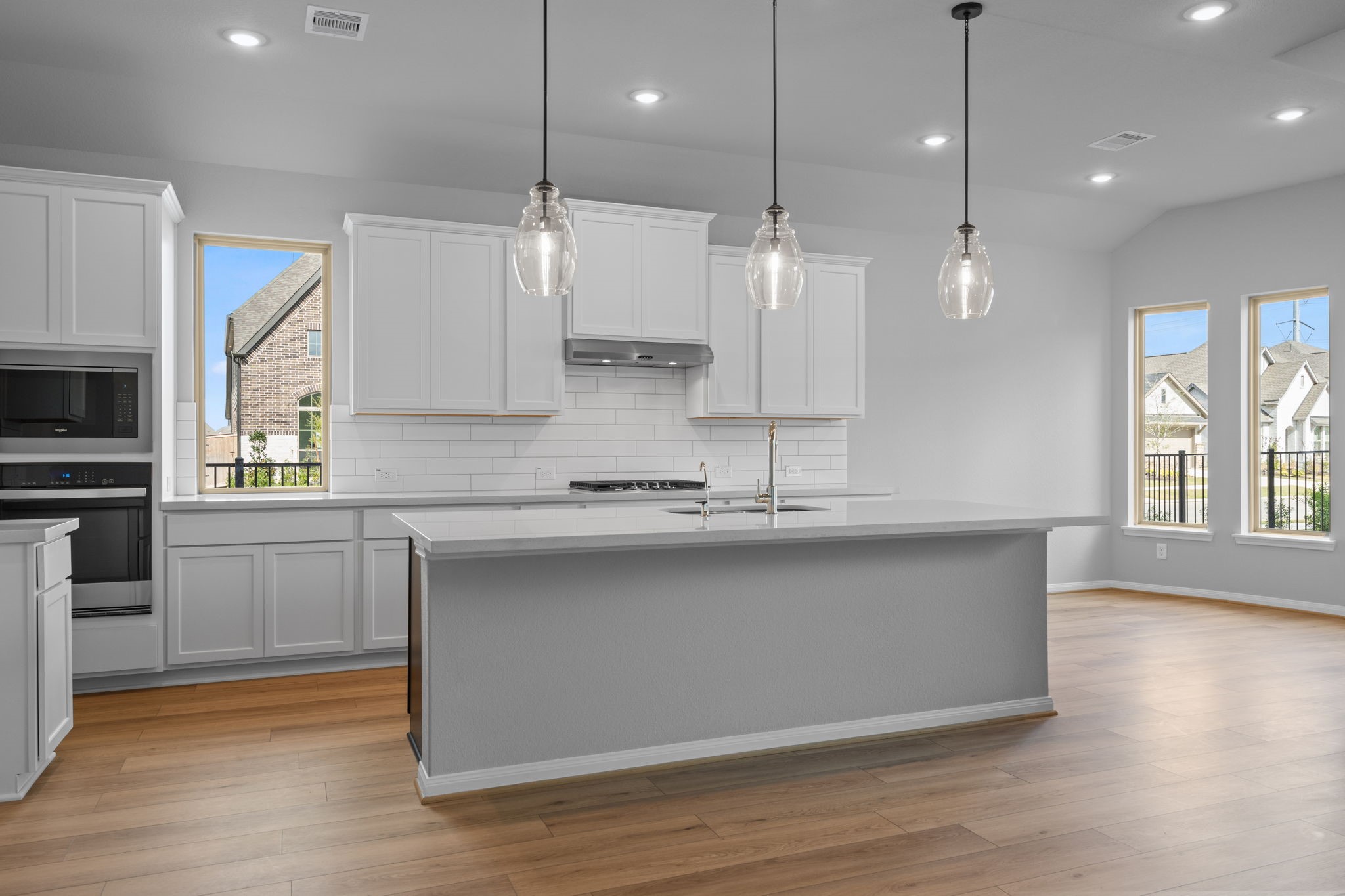 10726 Rattlebox Court Cypress, TX 77433 - Photo 5 of 36 a large kitchen with granite countertop a stove a sink a center island a refrigerator and a wooden floor