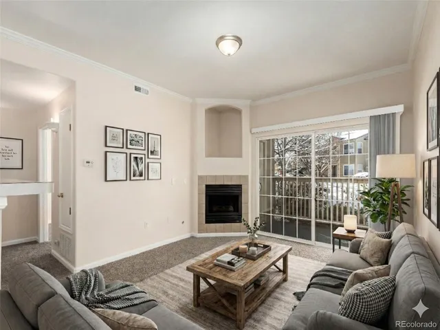 a living room with furniture a fireplace and a large window