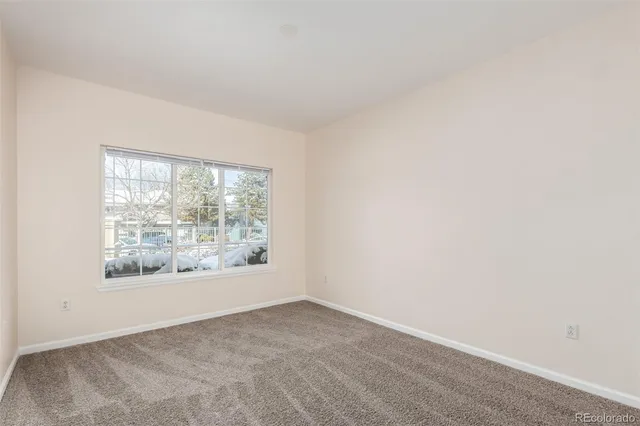 an empty room with windows and back yard