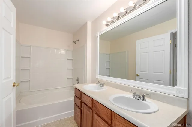 a bathroom with a sink shower and a mirror