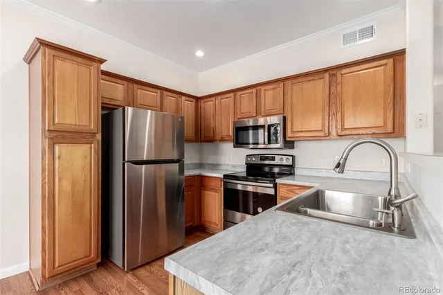 a kitchen with stainless steel appliances granite countertop a refrigerator stove top oven a sink and dishwasher