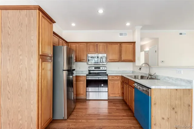 a kitchen with stainless steel appliances granite countertop a refrigerator a sink and a stove