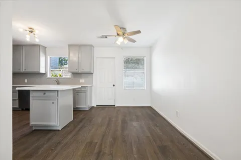 a kitchen with a sink cabinets and wooden floor