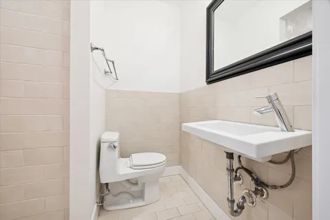 a bathroom with a sink a toilet and a mirror