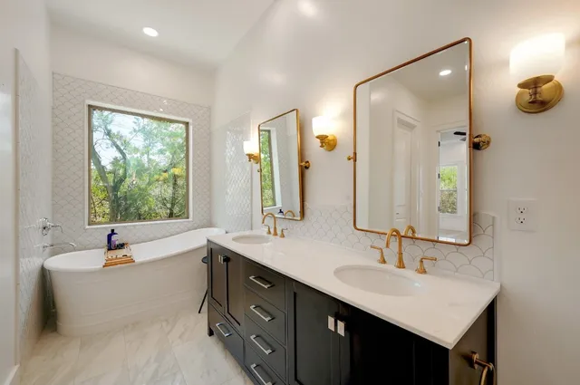 a bathroom with a tub sink and mirror