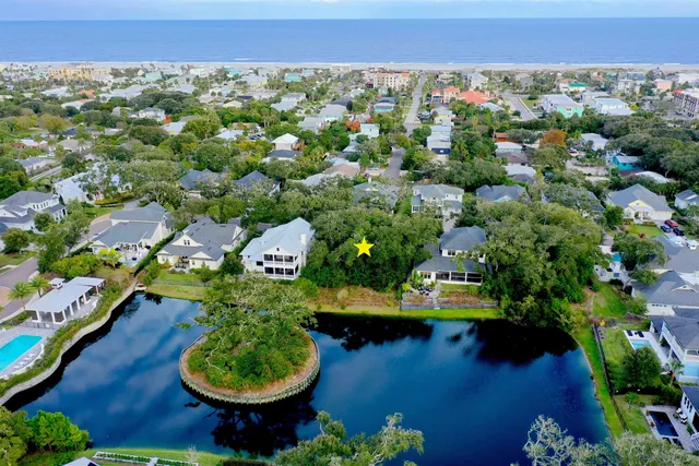 an aerial view of a house with a yard and lake view