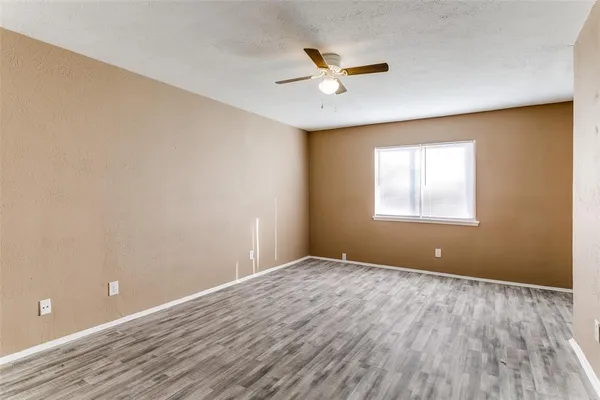 a view of a big room with wooden floor and windows