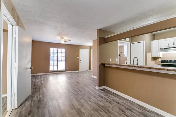 a view of a kitchen with wooden floor and a window