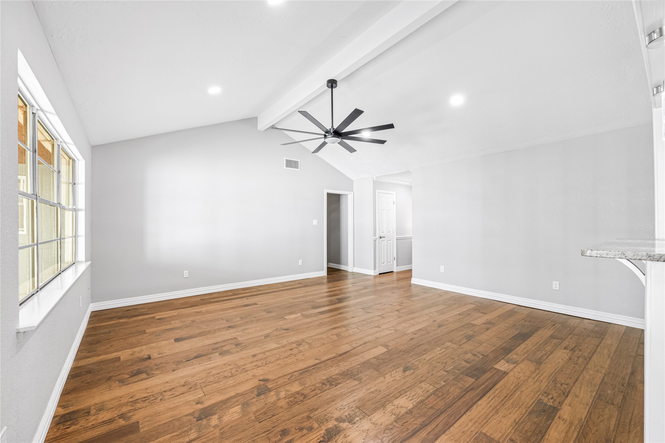 9806 Tanager Lane Conroe, TX 77385 - Photo 9 of 28 wooden floor in an empty room with a window