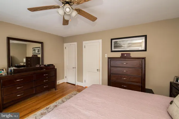 a bedroom with a bed and a mirror on the dresser