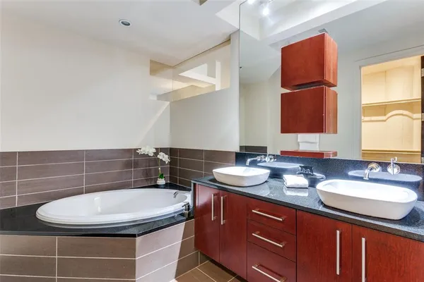 a bathroom with a granite countertop sink a mirror and shower