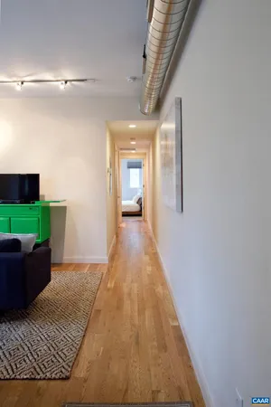 a view of a hallway with wooden floor and stairs