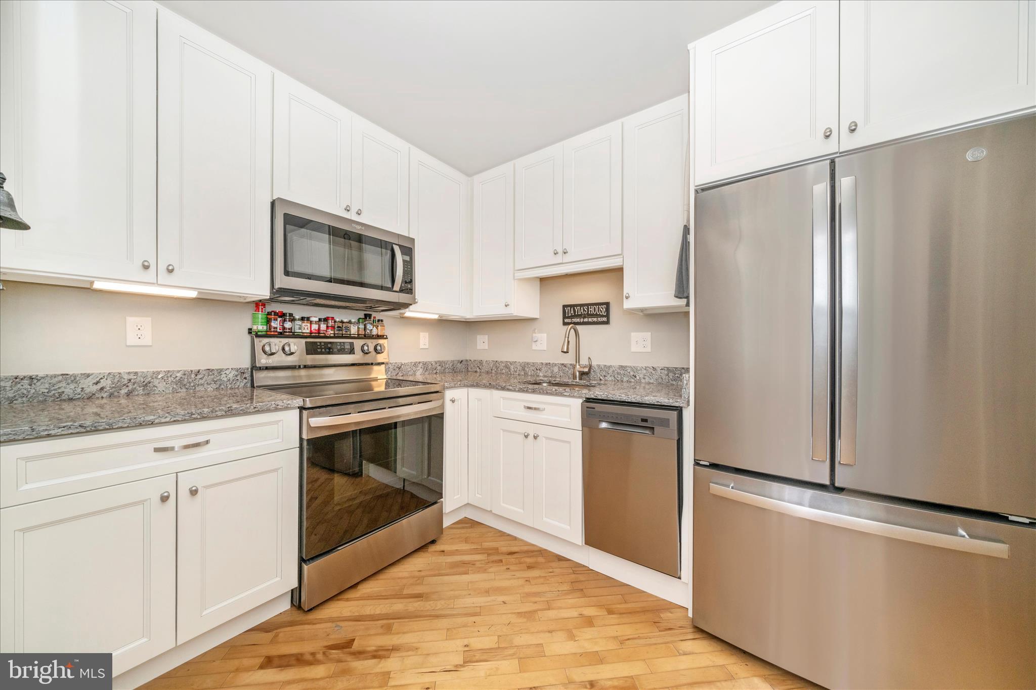 103 East 8th Street, Unit 103C Frederick, MD 21701 - Photo 12 of 34 a kitchen with stainless steel appliances granite countertop a refrigerator stove a sink and white cabinets