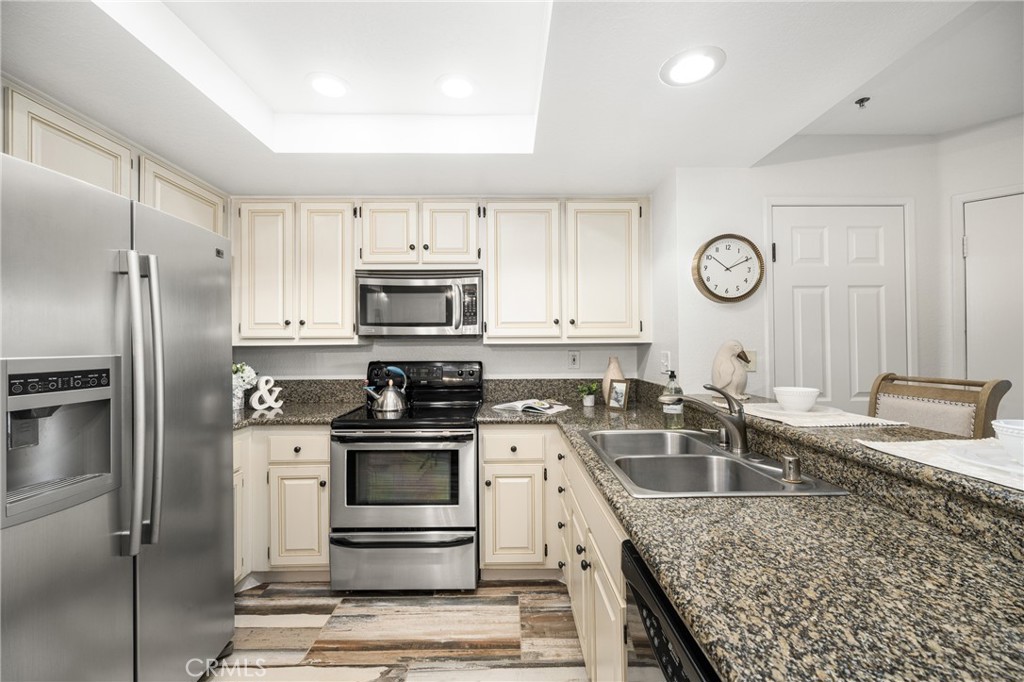 2800 Keller Drive, Unit 252 Tustin, CA 92782 - Photo 9 of 44 a kitchen with granite countertop a sink stove and refrigerator