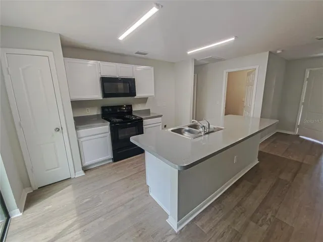 a kitchen with a sink and a stove top oven