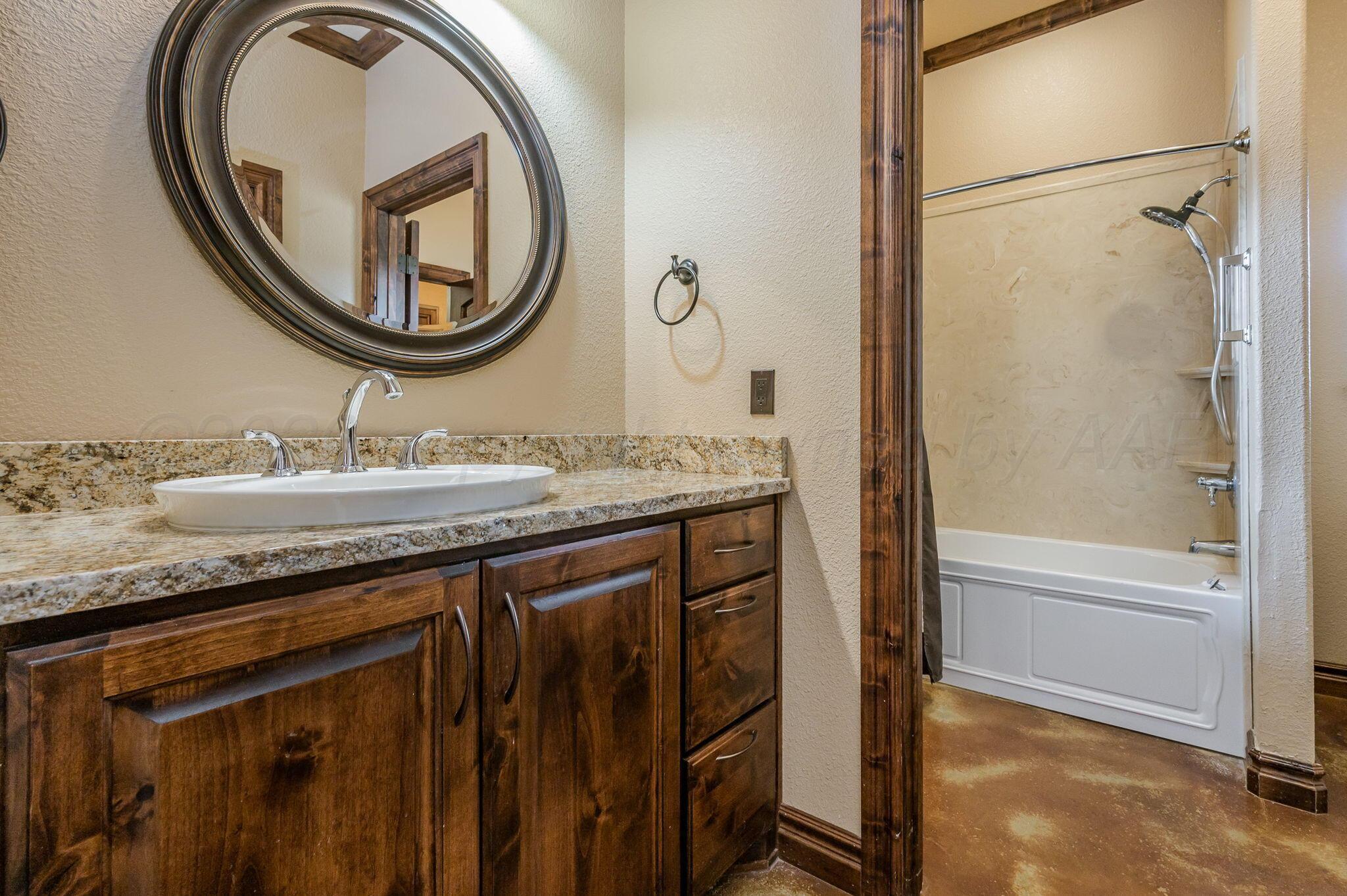 8150 Little Fox Trail Amarillo, TX 79118 - Photo 33 of 69 a bathroom with a granite countertop sink a mirror and a shower