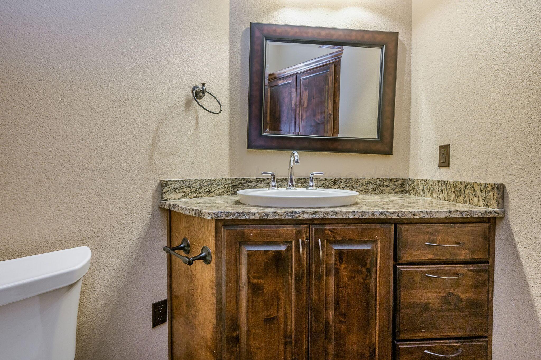 8150 Little Fox Trail Amarillo, TX 79118 - Photo 35 of 69 a bathroom with a granite countertop sink a toilet and mirror