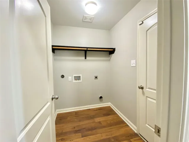 a view of a room with wooden floor and white walls