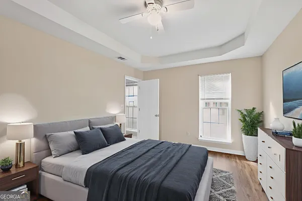 a bedroom with a large bed and a flat tv screen on dresser