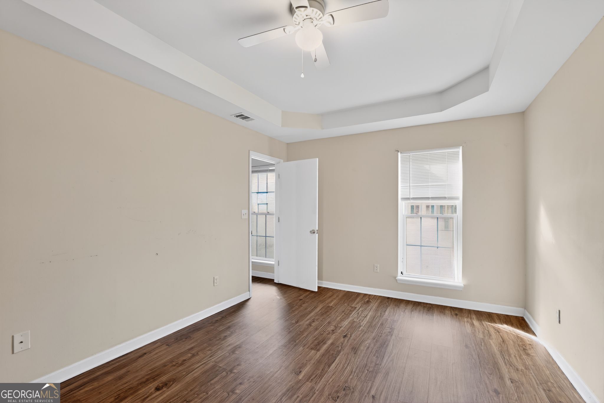 2764 Davis Mill Road Hephzibah, GA 30815 - Photo 17 of 29 an empty room with wooden floor chandelier fan and windows