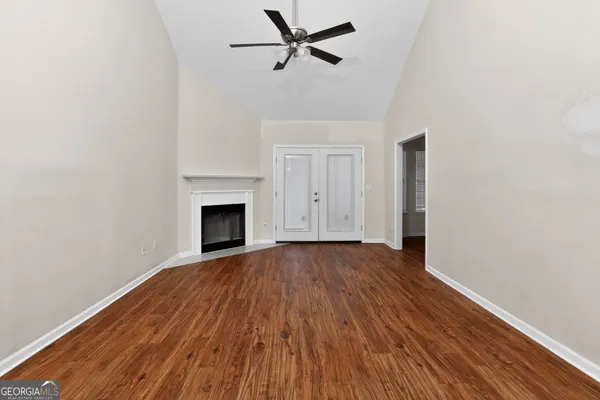 a view of empty room with wooden floor and fireplace